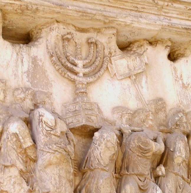 Jewish menorah, found on the inner wall of the Arch of Titus, an arch constructed in Rome by Domitian to celebrate the military victory of his brother, Titus, over the Jews. The spoils of war are displayed to commemorate the total destruction of Jerusalem and the Jewish temple there (AD 70). This photo is from Wikimedia and has been released into public domain.  Page 75, figure 39.