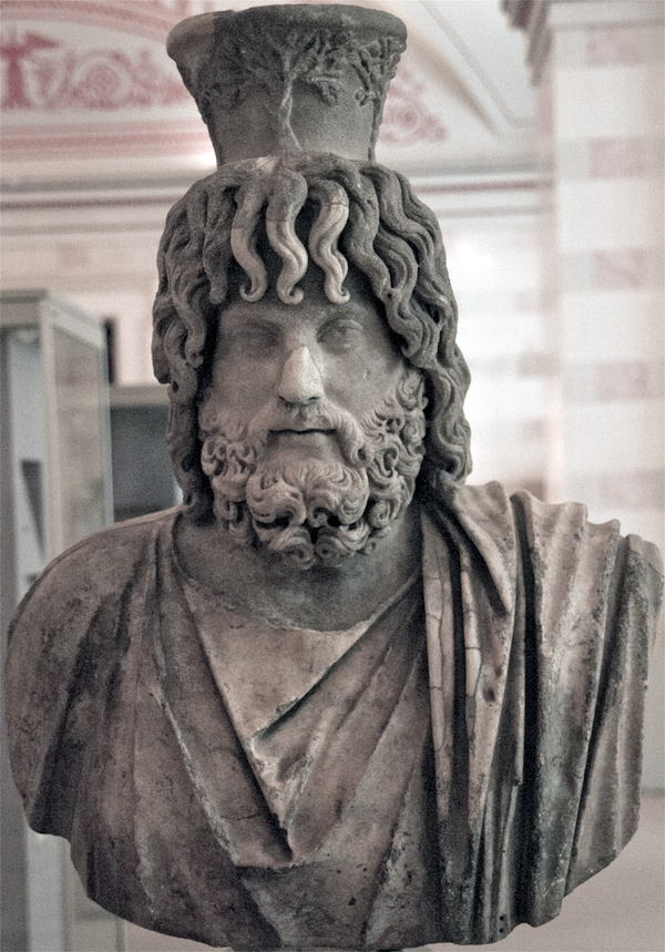 This statue represents a standard view of the Hellenistic-Egyptian deity Serapis, with a modius on his head. The modius represented a basket/measure of grain and thus bounty. The State Hermitage Museum, St. Petersburg, Russia.  © copyright holder of this work is Richard E. Oster.  Page 91, figure 50.